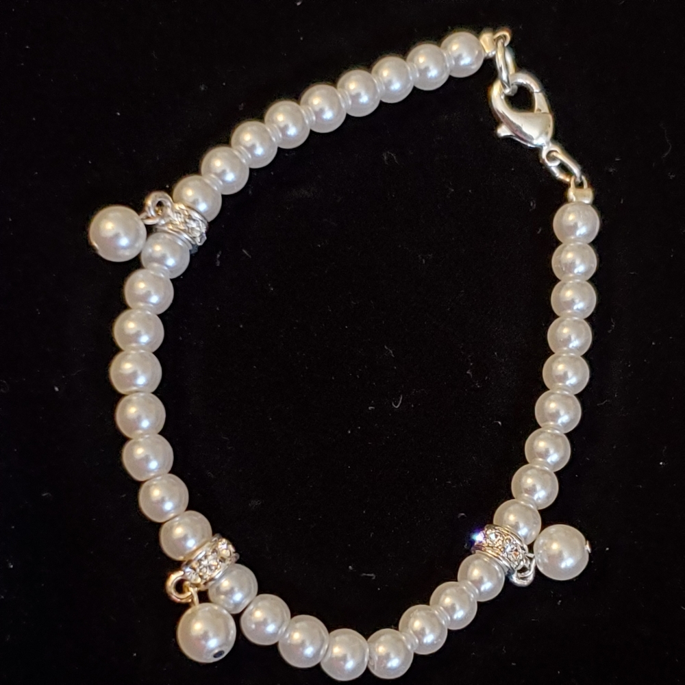 Delicate white faux pearl bracelet with pearl and rhinestones charms